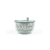 Green salad spinner with hand on lid, shown with fresh mixed leaves on kitchen worktop
