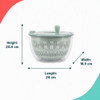 Green salad spinner with hand on lid, shown with fresh mixed leaves on kitchen worktop