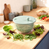 Green salad spinner with clear bowl and lid, shown from the front.