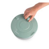 Hand using green manual salad spinner, top view