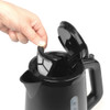 Hand removing filter from black electric kettle with open lid, showing easy cleaning feature