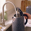 Grey leopard print kettle pouring hot water into a mug