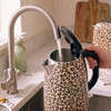 Beige leopard print electric kettle being filled at a kitchen tap
