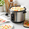 Stainless steel rice cooker with cooked rice and vegetables, shown on UK kitchen worktop.