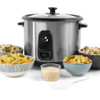 Silver electric rice cooker with cooked vegetable rice, bowl and serving spoon