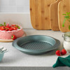 Round non-stick cake tin with textured base on kitchen counter