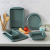 Set of green textured non-stick baking trays and pans on kitchen counter
