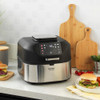 Hand pressing control panel on black and silver electric grill air fryer on kitchen counter