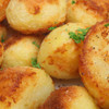 Close-up of golden roast potatoes with parsley garnish