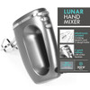 Silver hand mixer with beaters, lemon meringue pie and lemons on kitchen worktop