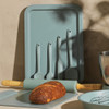 Green baking tray set with spatulas, rolling pin, and fresh loaf, kitchen tools promo