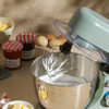 Teal stand mixer with stainless steel bowl, shown from the side