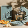 Teal stand mixer with large stainless steel mixing bowl, shown from the front.