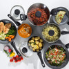 Black non-stick saucepan and frying pan set with glass lids shown in a modern kitchen