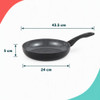 Set of three black non-stick frying pans with cooked fish, chicken, and vegetables.