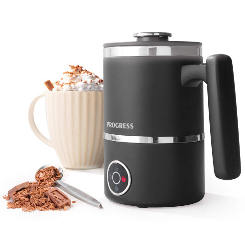 Black electric milk frother with handle, next to a mug of hot chocolate and chocolate shavings