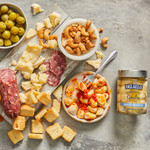 Jar of DeLallo Marinated Garlic jar arranged with assorted olives and cheese