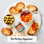 The perfect appetizer - roasted pepper bruschetta on a charcuterie board with bread and olives The perfect appetizer - roasted pepper bruschetta on a charcuterie board with bread and olives