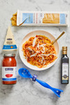 DeLallo bucatini pasta, marinara sauce, olive oil and pecorino romano cheese in product packaging laying on a marble table DeLallo bucatini pasta, marinara sauce, olive oil and pecorino romano cheese in product packaging laying on a marble table