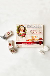 Front image of our box of Italian Soft Torrone Nougat Candy with some single pieces to the sides of the box.