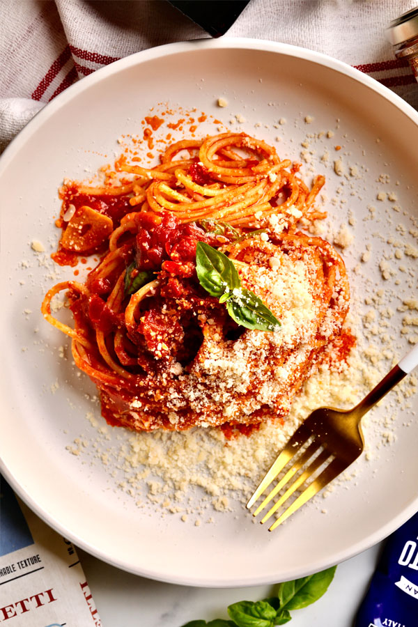 Spaghetti in a tomato paste sauce topped with parmesan and basil.