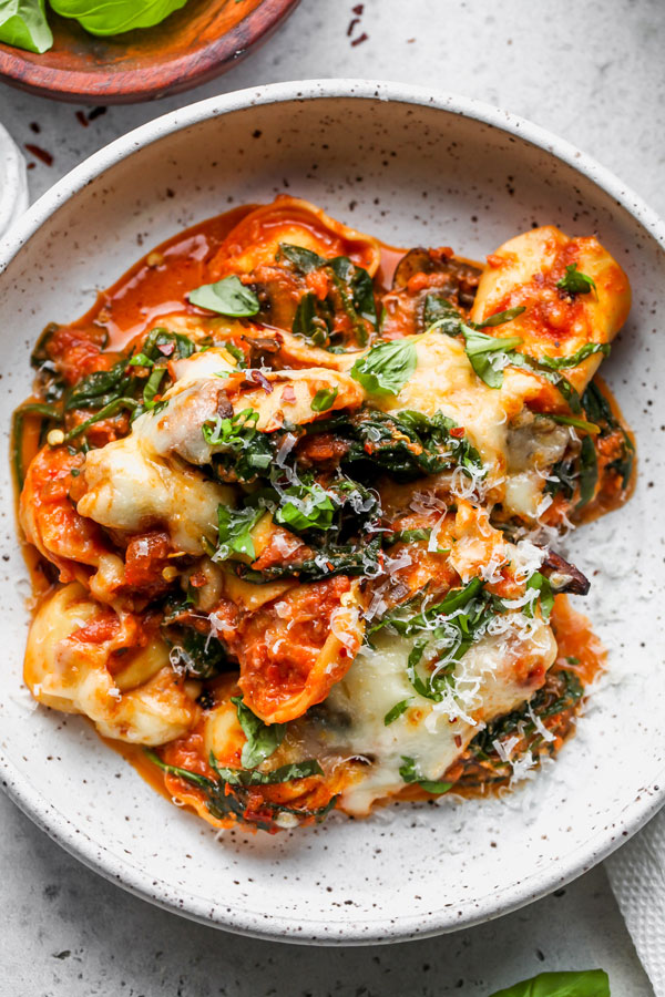 Tortellini on a plate with red sauce and cheese