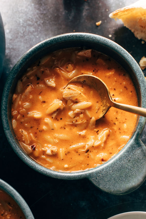 Bowl of chicken tomato orzo soup with a spoon