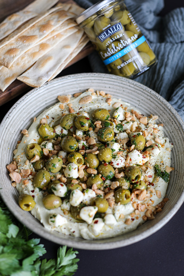 Olives and Mozzarella over Whipped Pesto Ricotta in a bowl and ready to serve