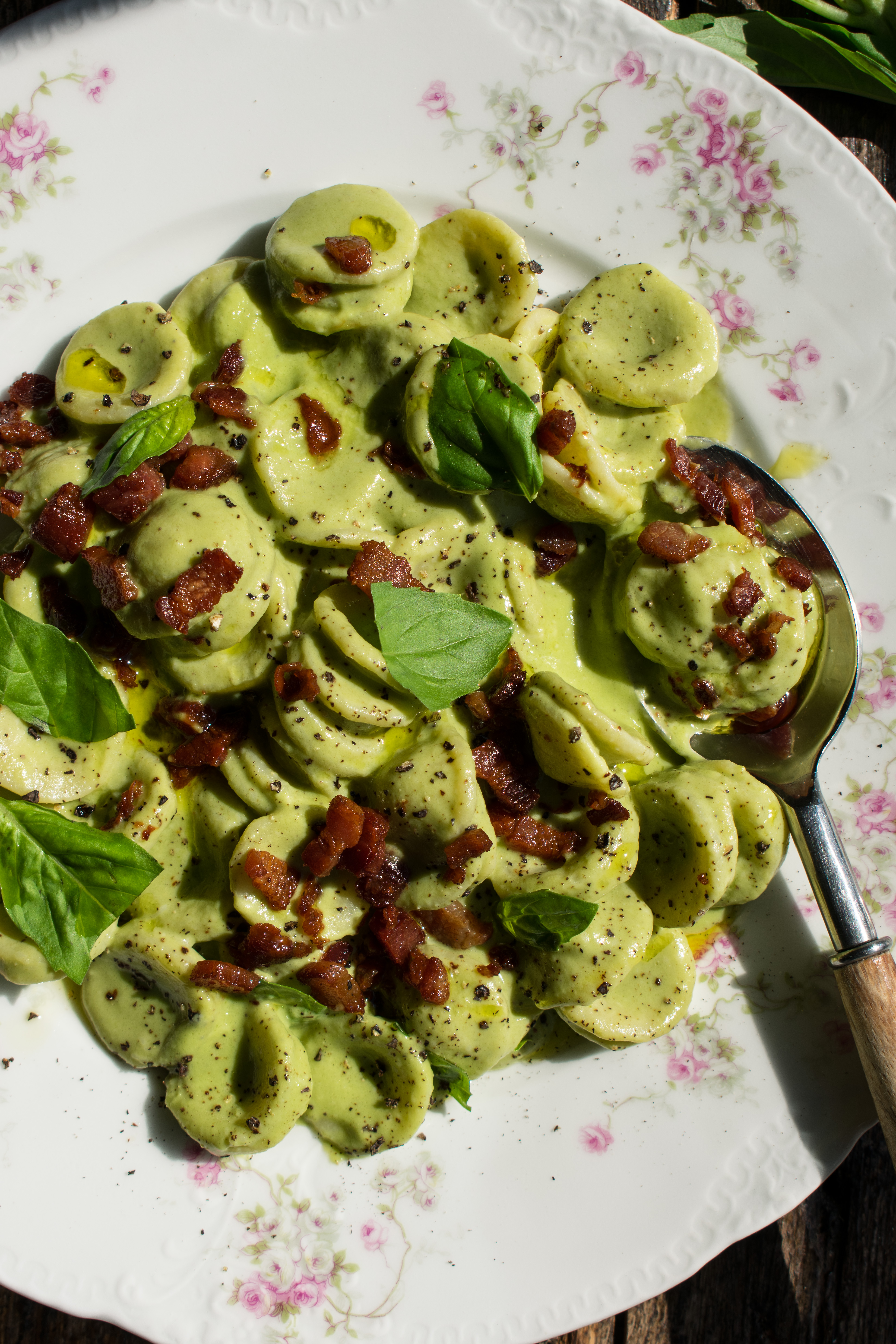 Creamy Basil Orecchiette with Peas and Pancetta served on a plate.