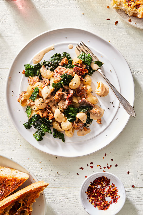 Pasta with kale and sausage in a creamy garlic sauce.