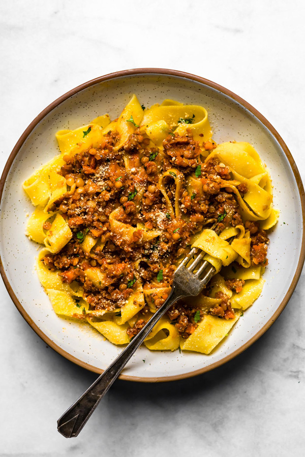 Vegetarian Lentil Bolognese served over pappardelle pasta on a plate.