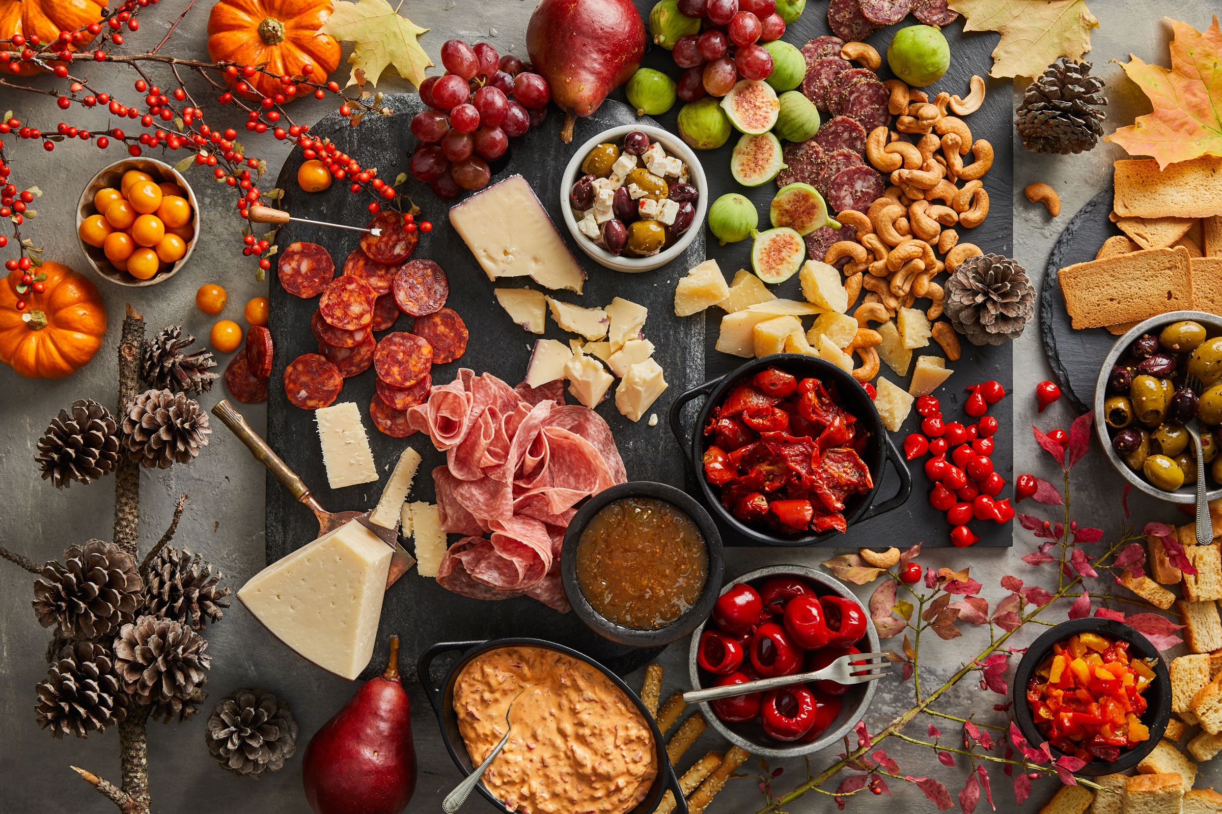 Fall themed charcuterie board with assorted olives, antipasti, meats, cheeses, fruit, nuts and more
