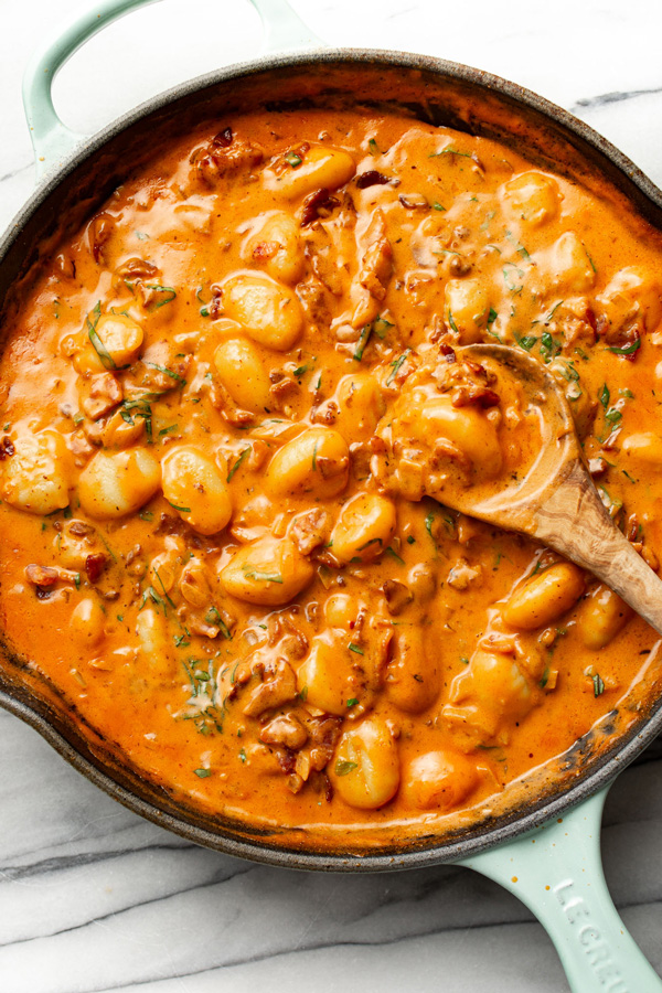 Spicy tomato gnocchi with bacon cooked in a pan and ready to serve