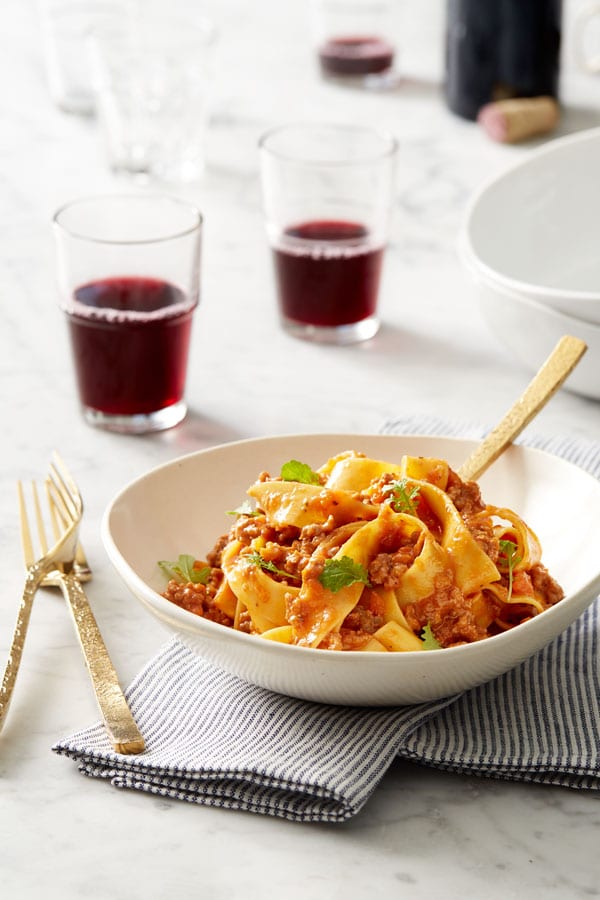 Pasta placed in a white bowl with bolognese sauce