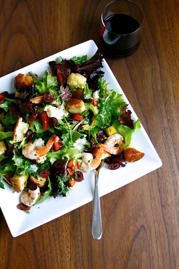 Finished salad with whole shrimp, croutons, and calamata olives