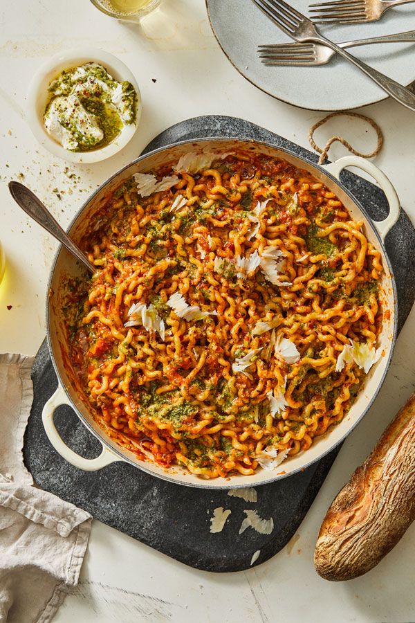 Fusilli pasta with red sauce, pesto and grated cheese in a pot