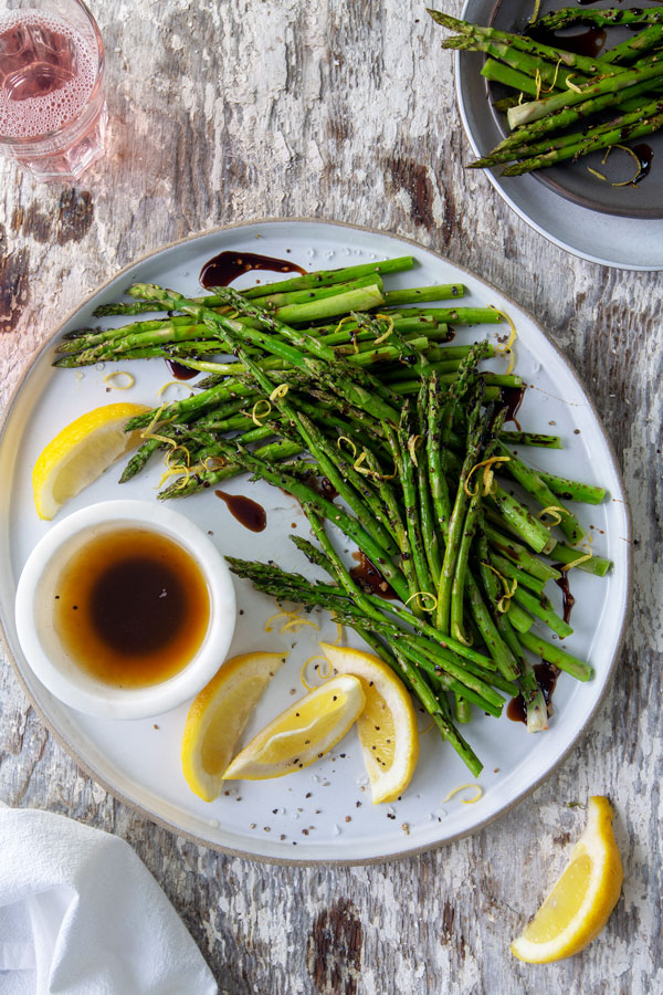 asparagus drizzled with balsamic on  white plate 