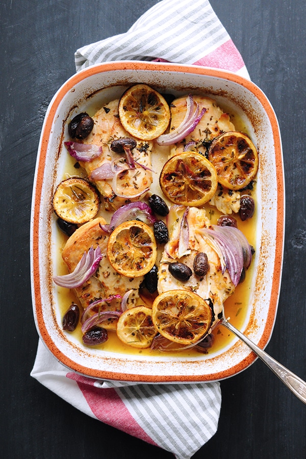 baked chicken topped with sliced lemon, red onions and calamata olives