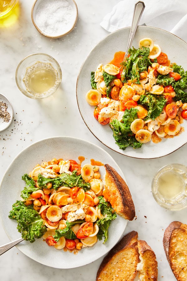 Pasta with chickpeas, tomatoes, and greens served on two dishes