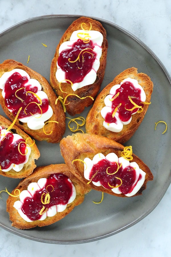 Toasted bruschetta with a fresh ricotta and sour cherry spread on top 