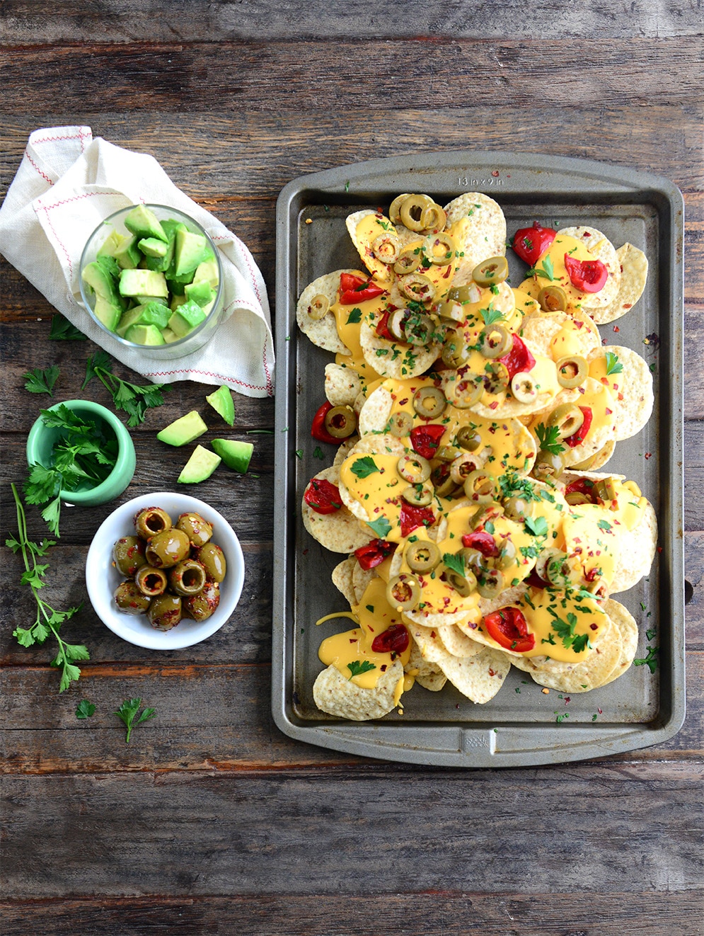 spicy nachos topped with olives and peppers