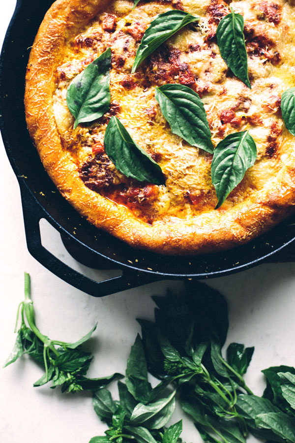 finished pizza topped with fresh basil leaves