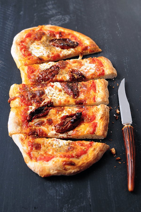 Finished tomato pizza cut into slices long ways