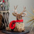 10.5" Sitting Reindeer with Buffalo Plaid Saddle Christmas Figure