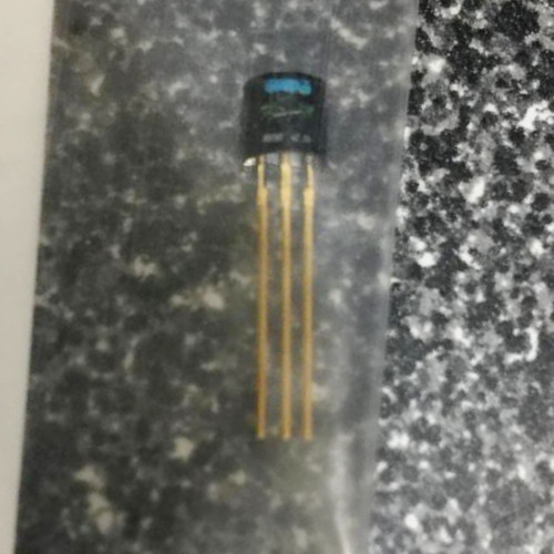 Small black molded three-lead transistor body with three straight gold-colored leads