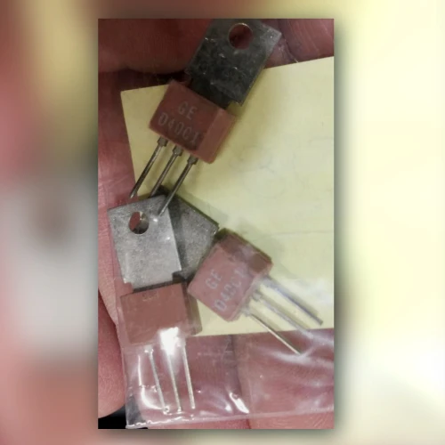 Three TO-202 Darlington transistors with metal tabs held in a hand, two marked GE D40C1