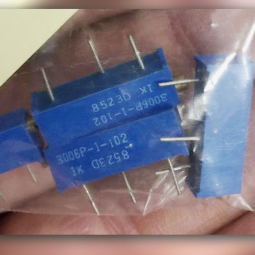 Four blue trimmer potentiometers, two with legible 3006P-1-102 markings, held in an open palm
