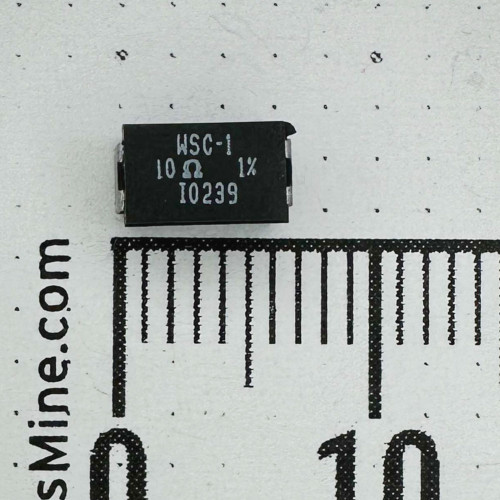 Black molded WSC-1 surface mount resistor, top face printed 10 ohm 1%, on gray surface