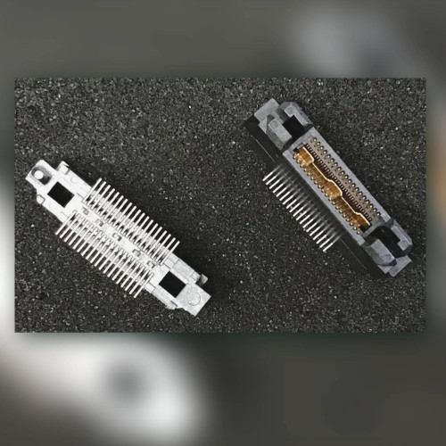 Two fine-pitch vertical plug connectors, one face up with gold contacts, one showing metal underside