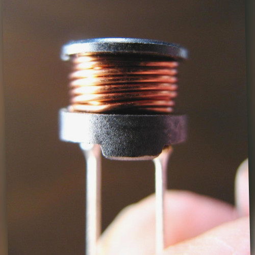Black drum core inductor, no marking visible, with bare copper winding and two radial leads